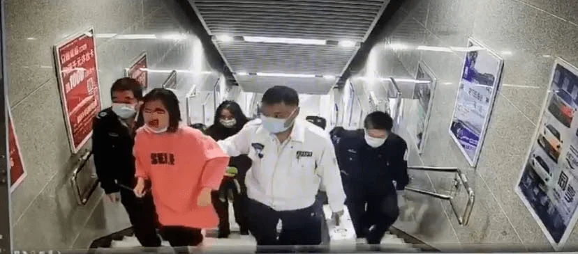 女孩地铁站下楼玩手机摔倒是怎么回事(女子地铁站摔下楼梯)2